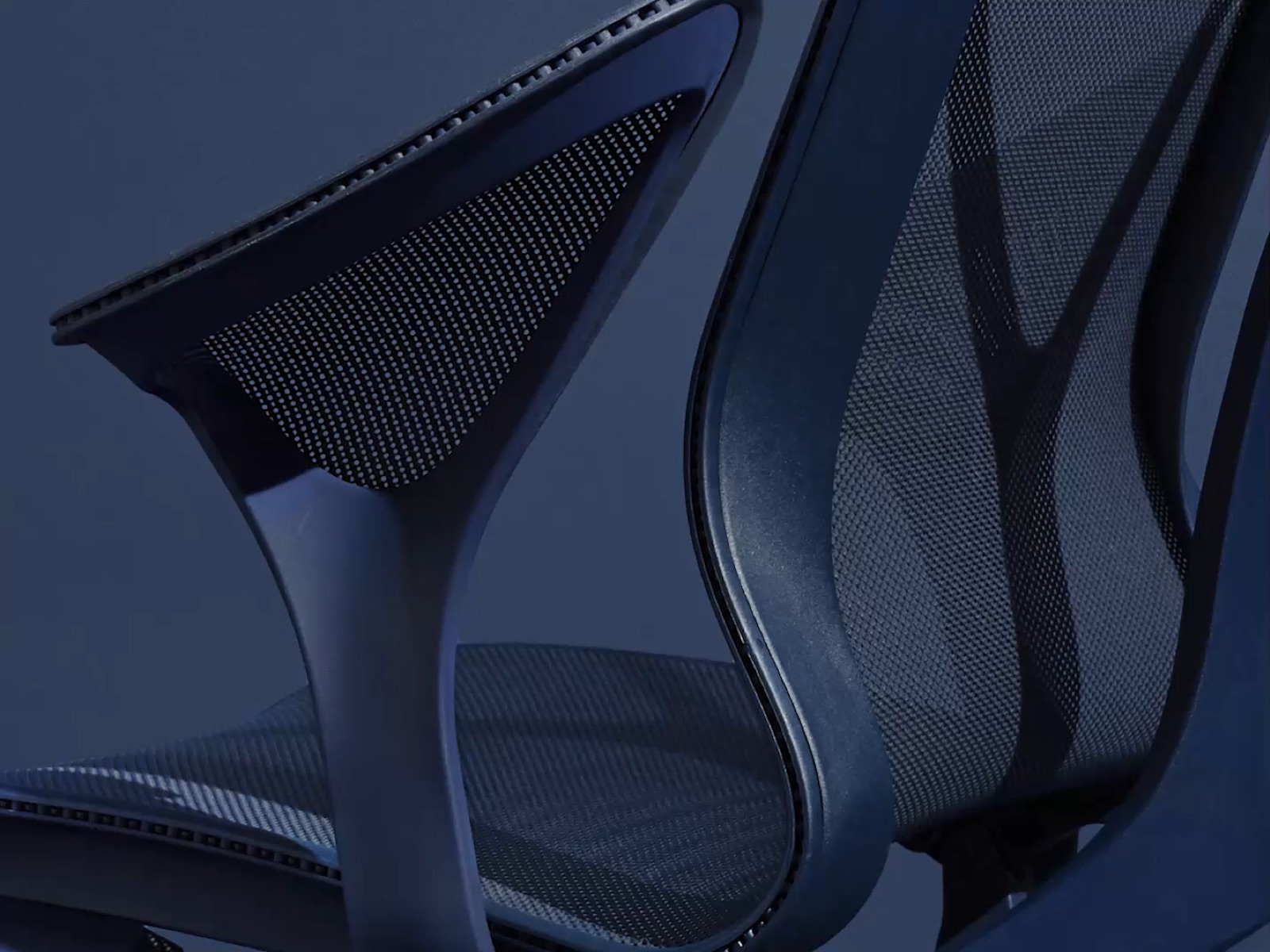 A close-up from behind of the leaf arm on a Nightfall dark blue Cosm ergonomic chair.
