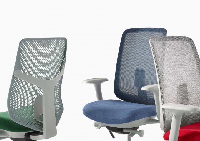 A close-up view of a Verus Chair with a green Triflex back, a Verus Chair with a blue seat and suspension back, and a Verus Chair with a grey suspension back with a red seat.