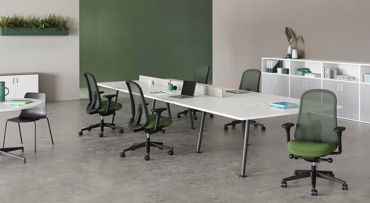 Five black and green Lino Chairs positioned around a large Memo desk. Paragraph units provide storage options around the room with a white Civic Table offering an alternative workspace.
