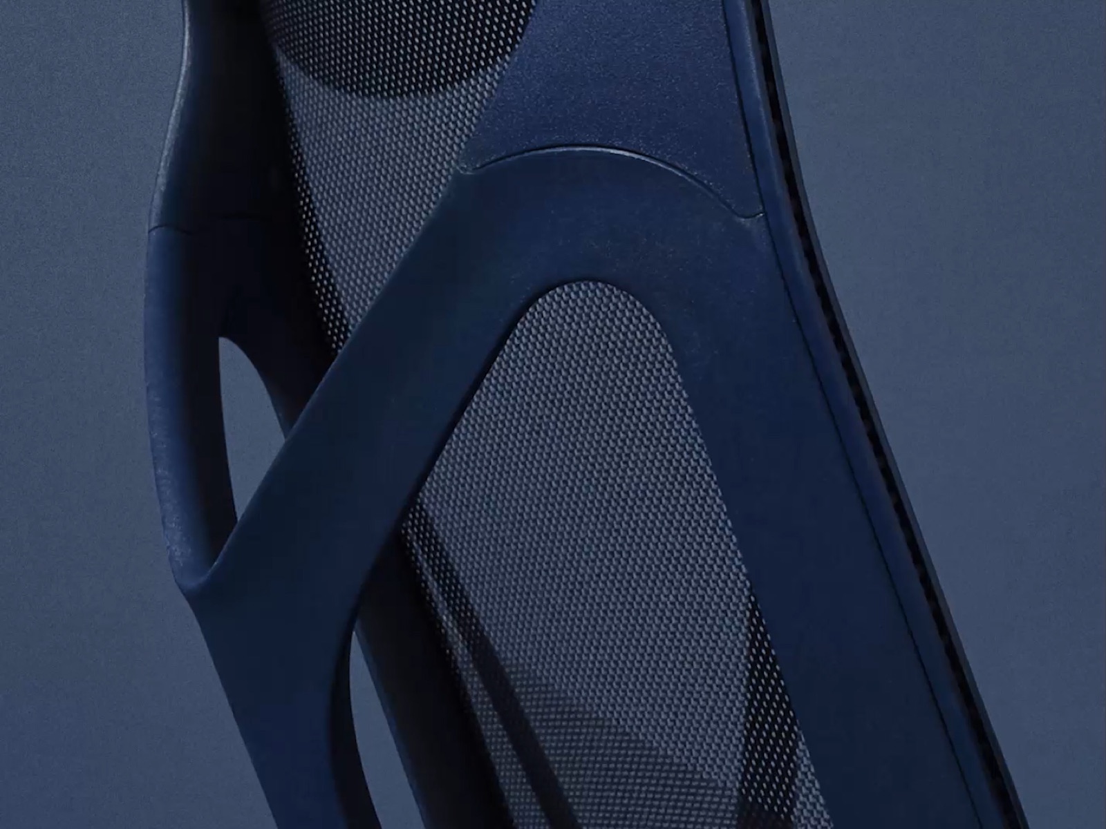 A close-up from behind of the frame of a Nightfall dark blue Cosm ergonomic desk chair.